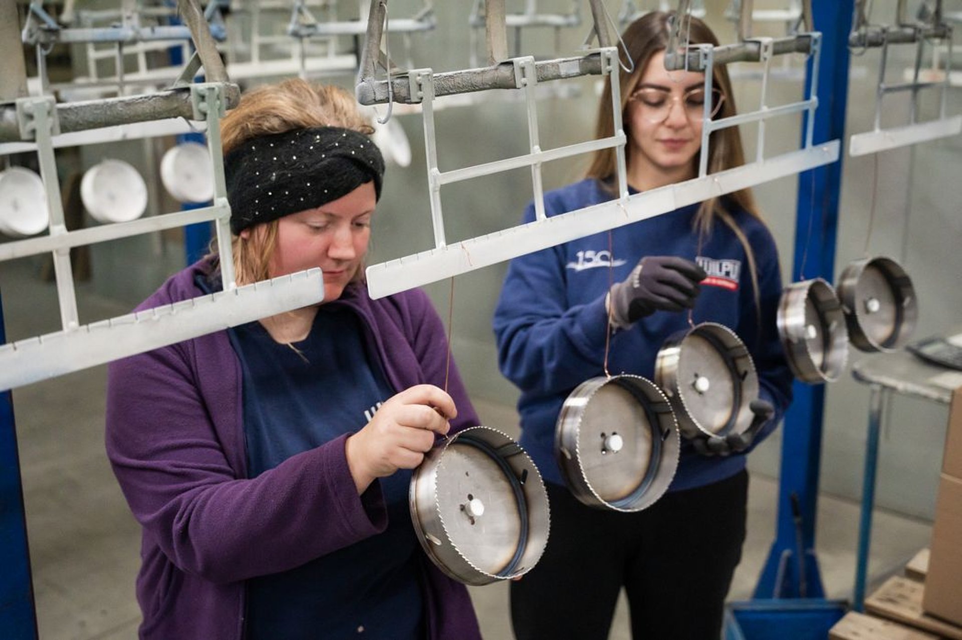 Eine inkludierte Mitarbeiterin arbeitet in der Produktion der Lochsägen Hand in Hand mit einer weiteren WILPU-Kollegin. Eine inkludierte Mitarbeiterin arbeitet in der Produktion der Lochsägen Hand in Hand mit einer weiteren WILPU-Kollegin.